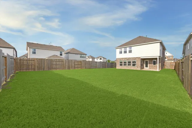 a view of a big house with a big yard and large trees