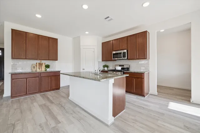 a kitchen with sink a microwave and refrigerator