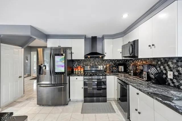 a kitchen with stainless steel appliances granite countertop a refrigerator stove and sink