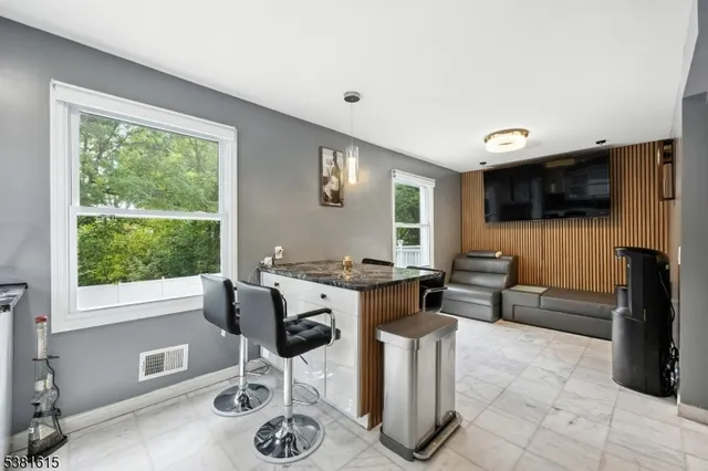 a living room with furniture a flat screen tv and a large window