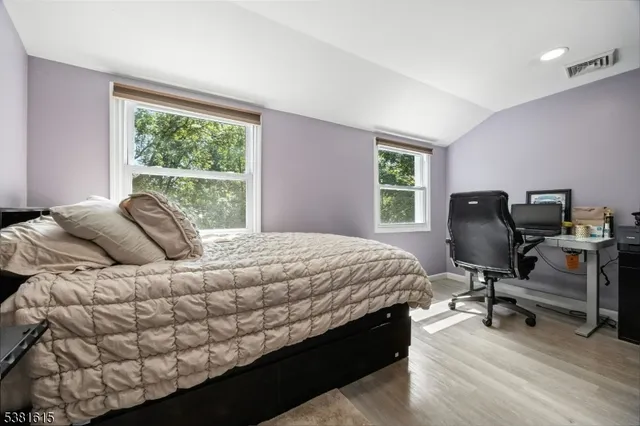 a bedroom with a bed a chair and a large window