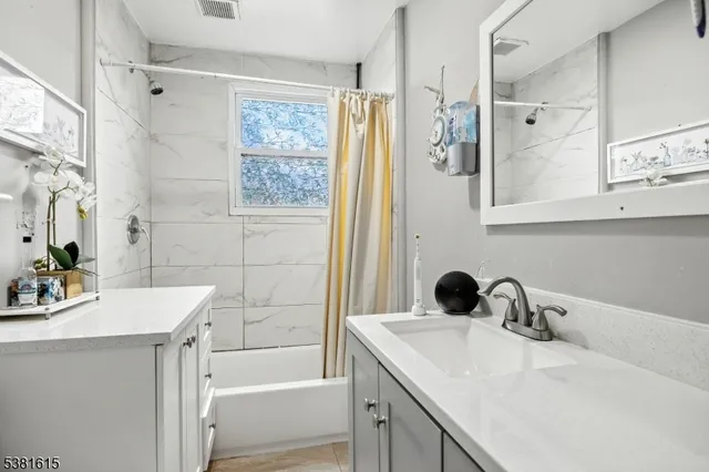 a bathroom with a tub sink and mirror
