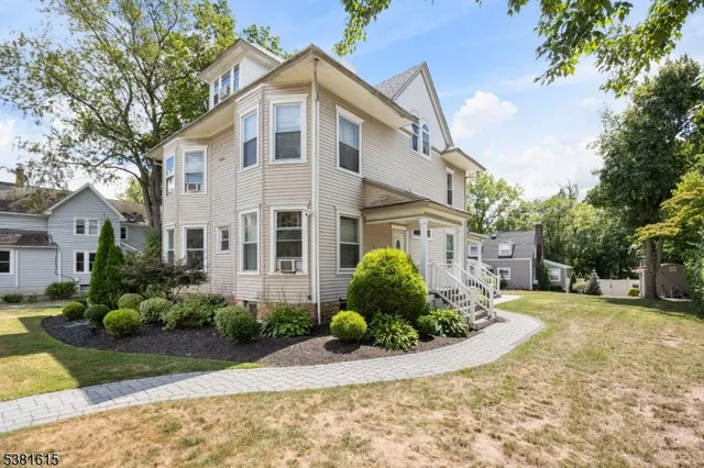 a front view of a house with a yard and plants