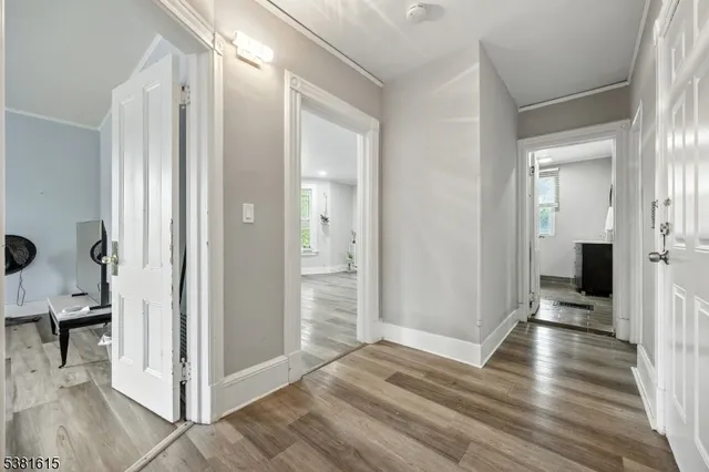 a view of a hallway with wooden floor and staircase