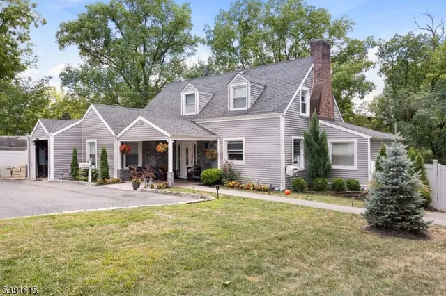 a front view of house with yard and trees in the background