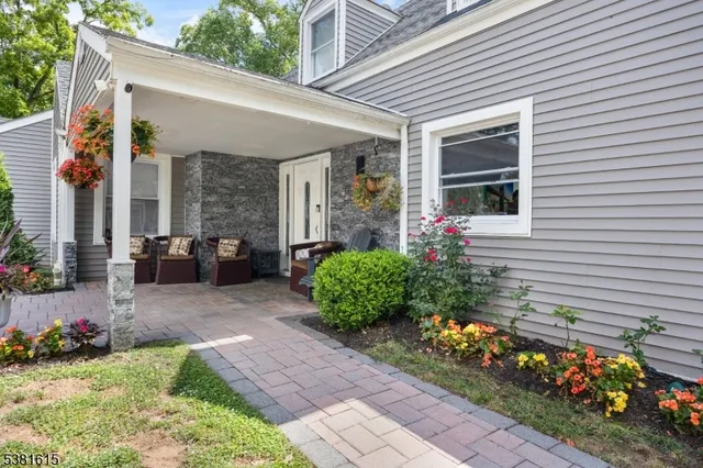 a front view of a house with a yard and potted plants