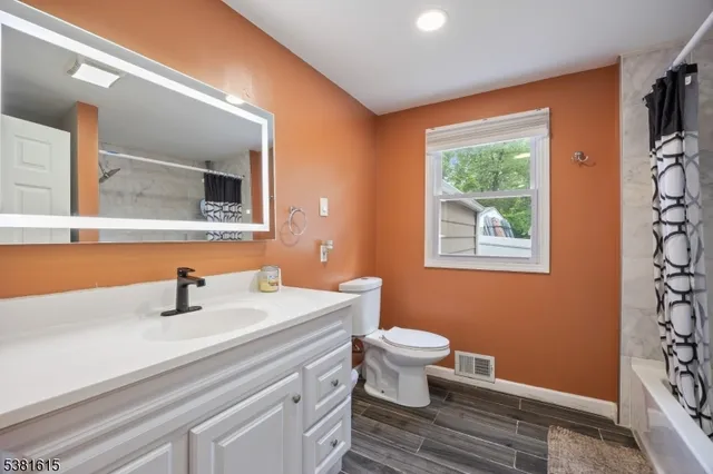 a bathroom with a sink a toilet and mirror