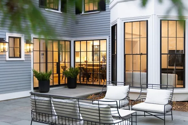 a view of a patio with table and chairs and a large tree
