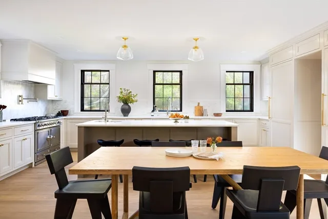a kitchen with a dining table chairs and window