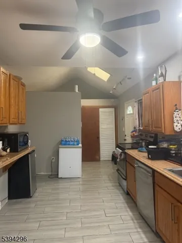 a large kitchen with a large counter top a sink a stove and a refrigerator