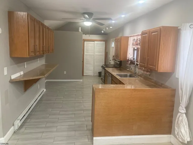 a view of a kitchen with stainless steel appliances granite countertop a sink and a refrigerator