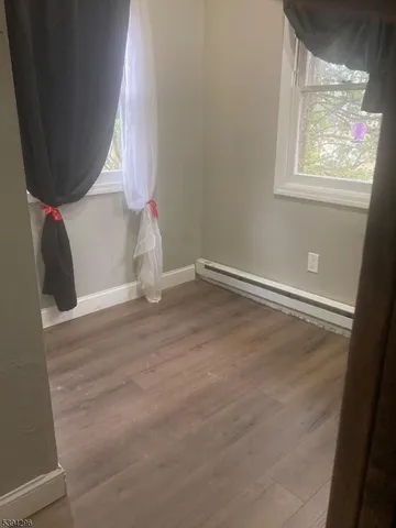 an empty room with wooden floor and window