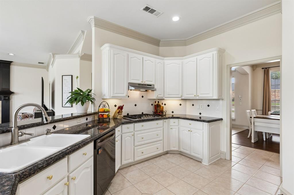 8517 Navigation Drive Rowlett, TX 75088 - Photo 12 of 39 a kitchen with a sink dishwasher and white cabinets
