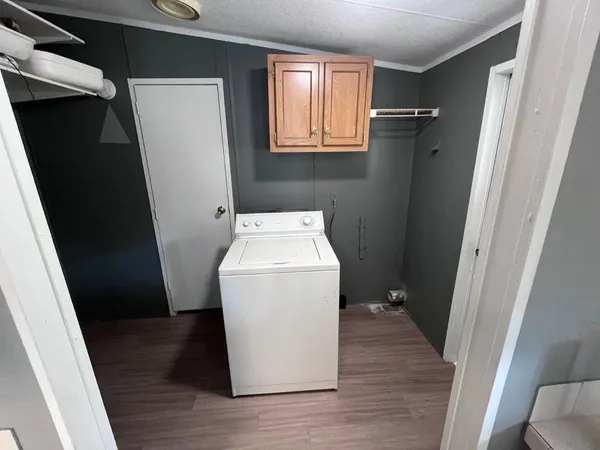 an empty room with wooden floor ceiling fan and windows