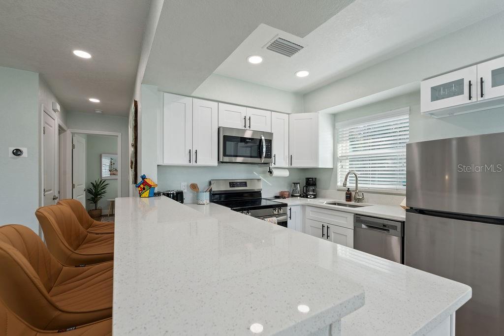 11987 Maple Street Dunnellon, FL 34432 - Photo 57 of 72 a kitchen with stainless steel appliances granite countertop a sink a stove a refrigerator a microwave oven with cabinets