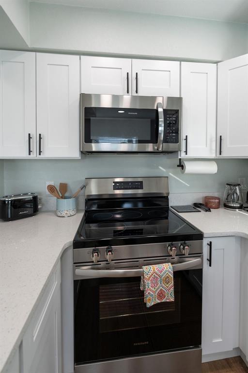 11987 Maple Street Dunnellon, FL 34432 - Photo 61 of 72 a kitchen with stainless steel appliances a stove a microwave and cabinets