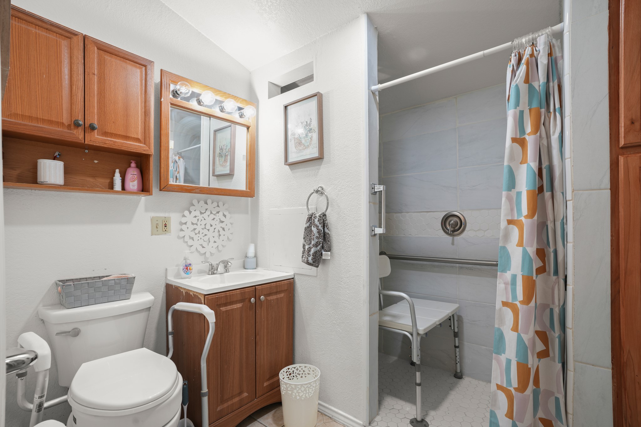 1908 Holly Street Austin, TX 78702 - Photo 14 of 22 Functional bath featuring a walk-in shower with a shower seat.