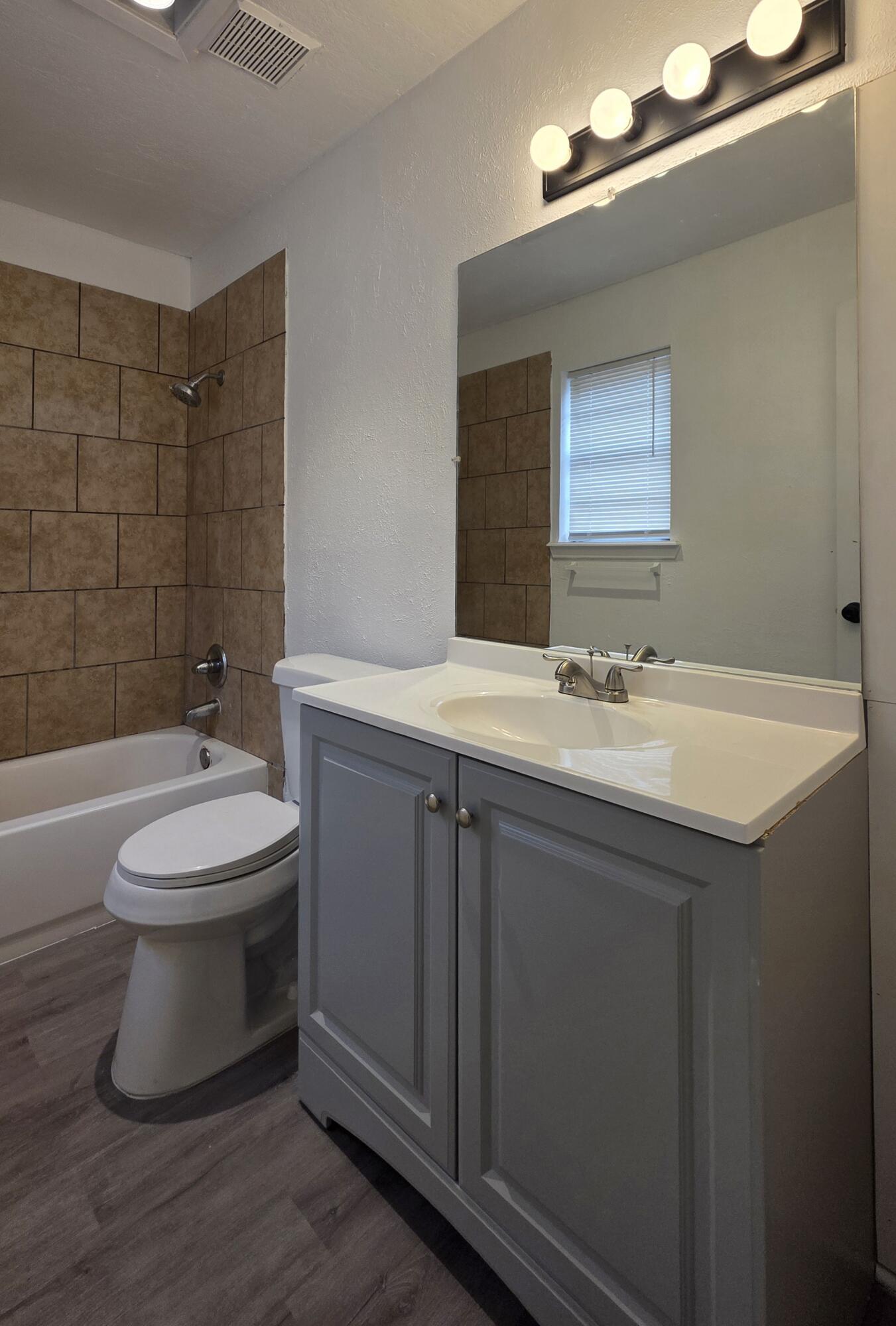 2307 78th Street Lubbock, TX 79423 - Photo 15 of 21 a bathroom with a sink mirror toilet and bathtub
