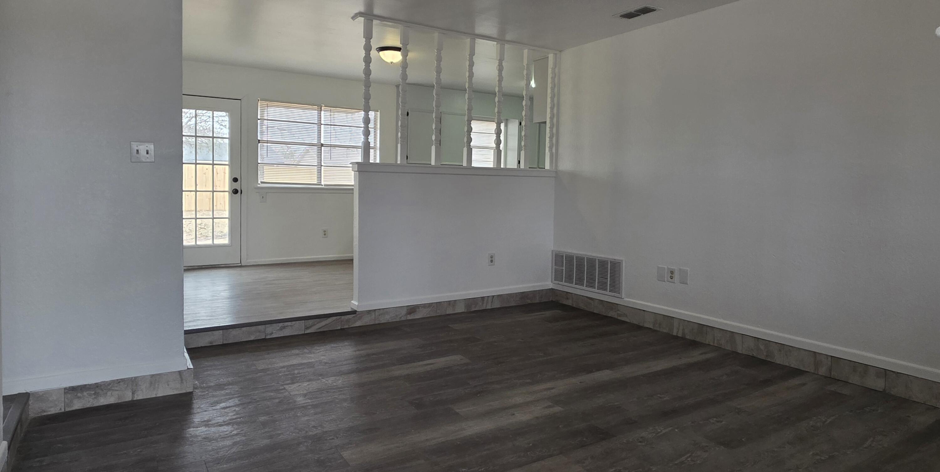 2307 78th Street Lubbock, TX 79423 - Photo 3 of 21 an empty room with wooden floor and windows