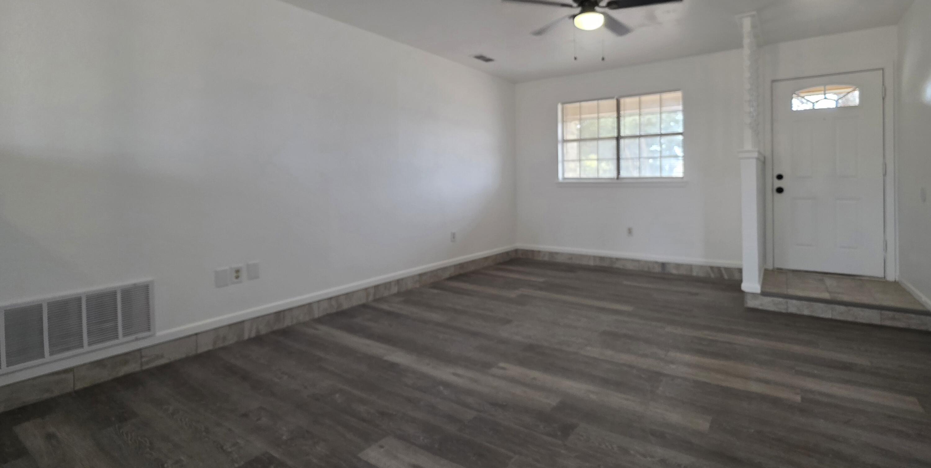 2307 78th Street Lubbock, TX 79423 - Photo 6 of 21 an empty room with wooden floor and windows