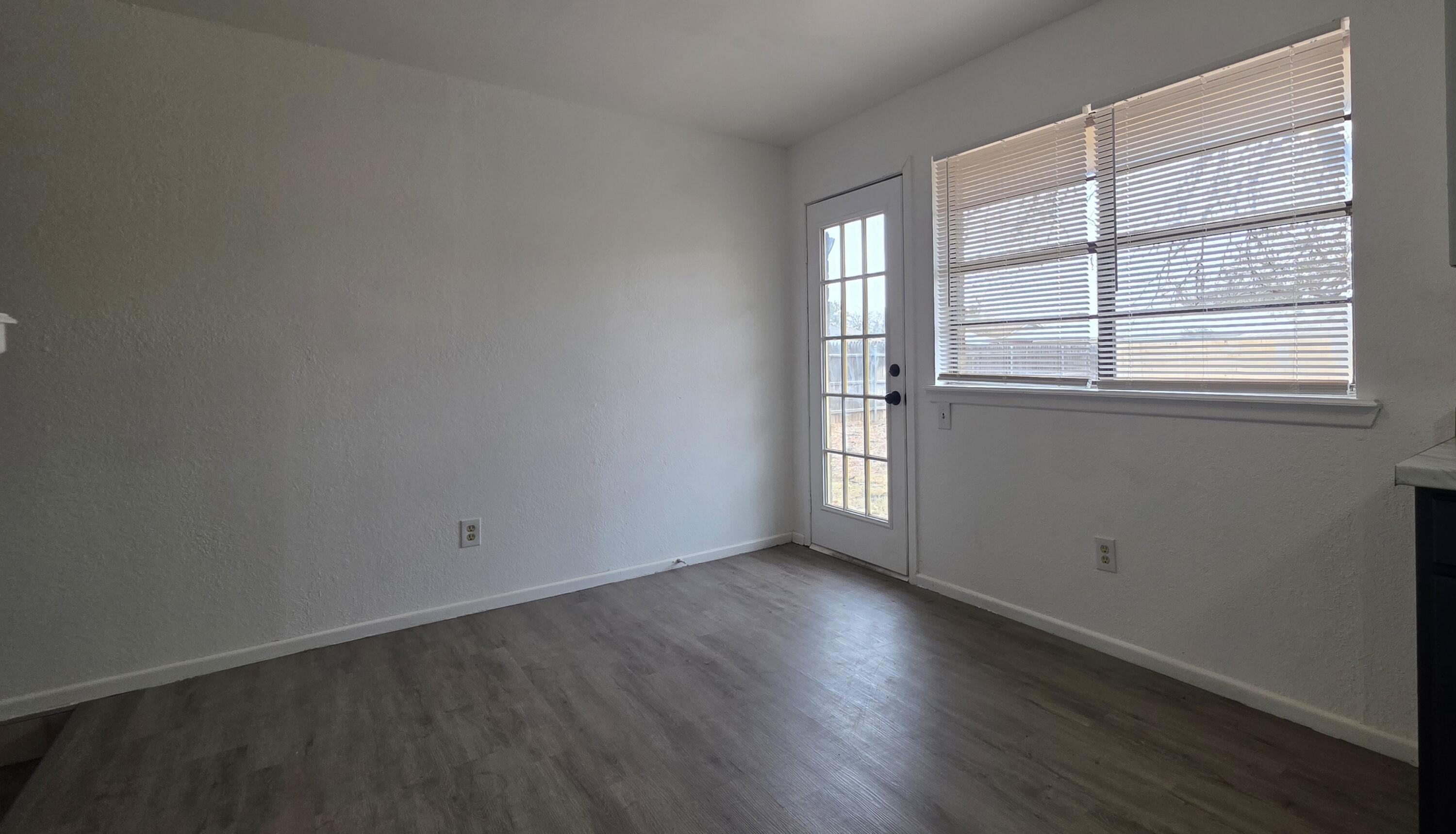 2307 78th Street Lubbock, TX 79423 - Photo 7 of 21 an empty room with wooden floor and windows