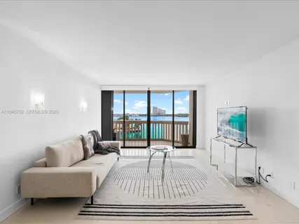 a living room with furniture a flat screen tv and a table