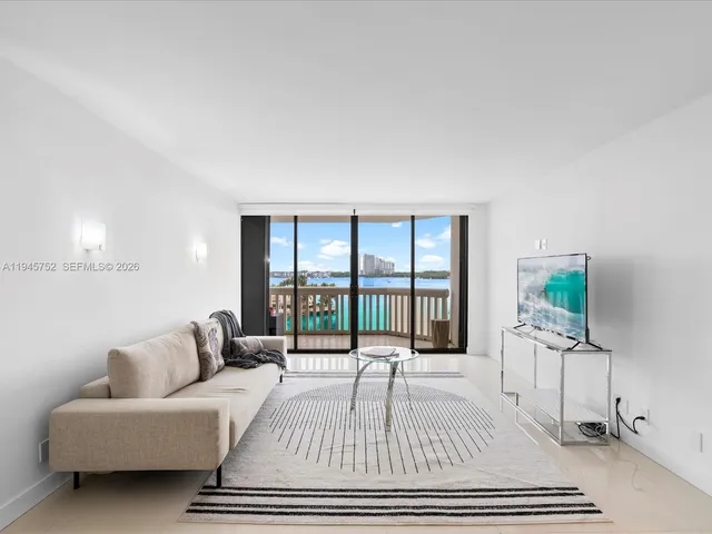 a living room with furniture a flat screen tv and a table