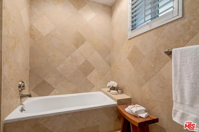a bath tub sitting next to a white toilet and sink