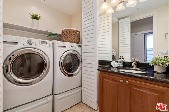 a utility room with sink dryer and washer