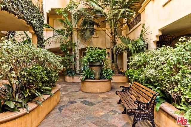 a view of a backyard with chair and potted plants