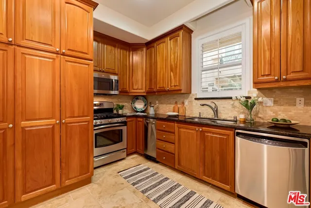 a kitchen with stainless steel appliances granite countertop a refrigerator and a sink