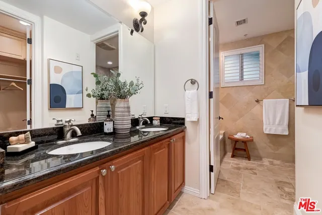 a bathroom with a granite countertop sink and a mirror