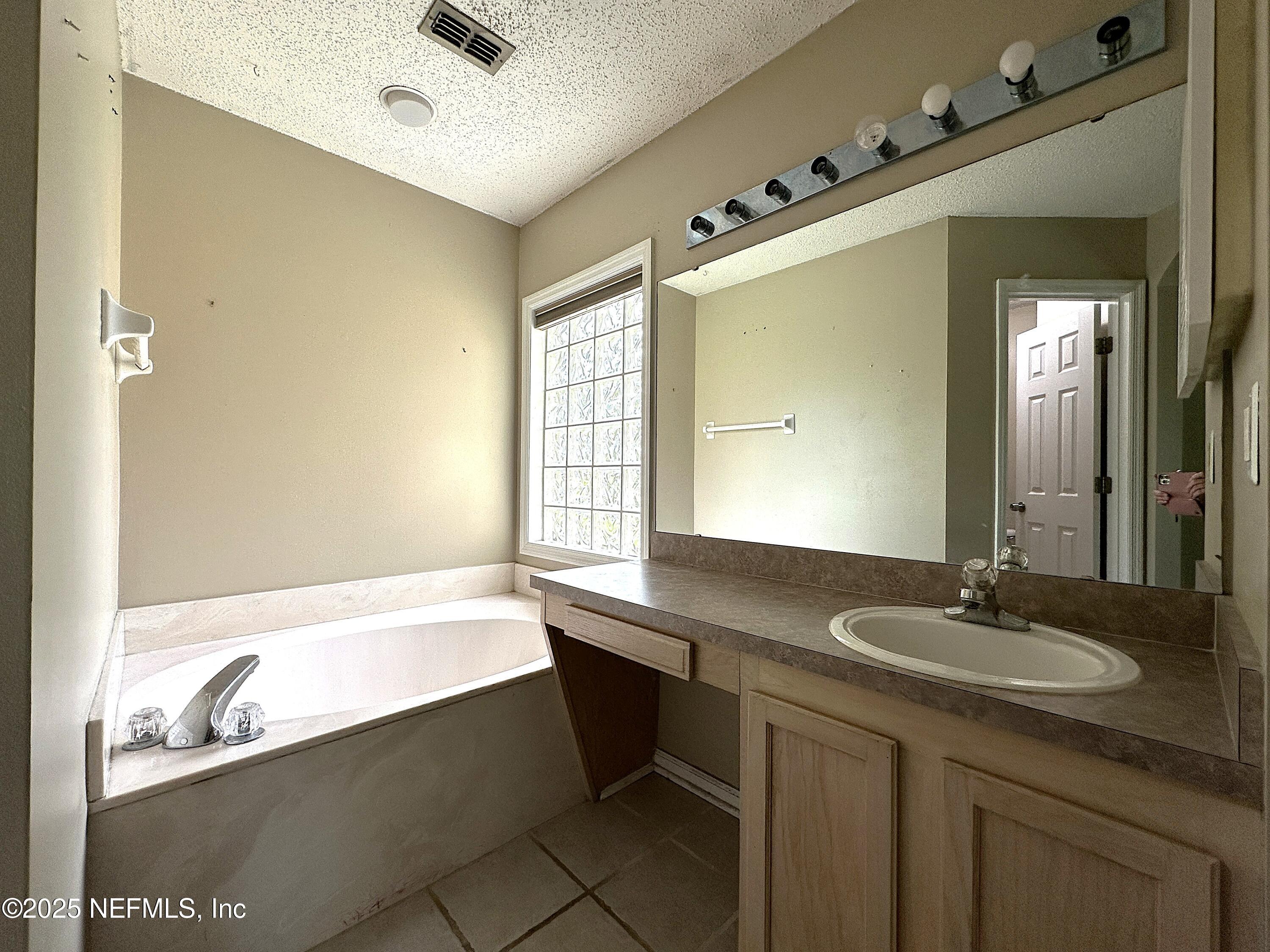 83041 St Mark Drive Yulee, FL 32097 - Photo 12 of 28 a bathroom with a tub sink and mirror