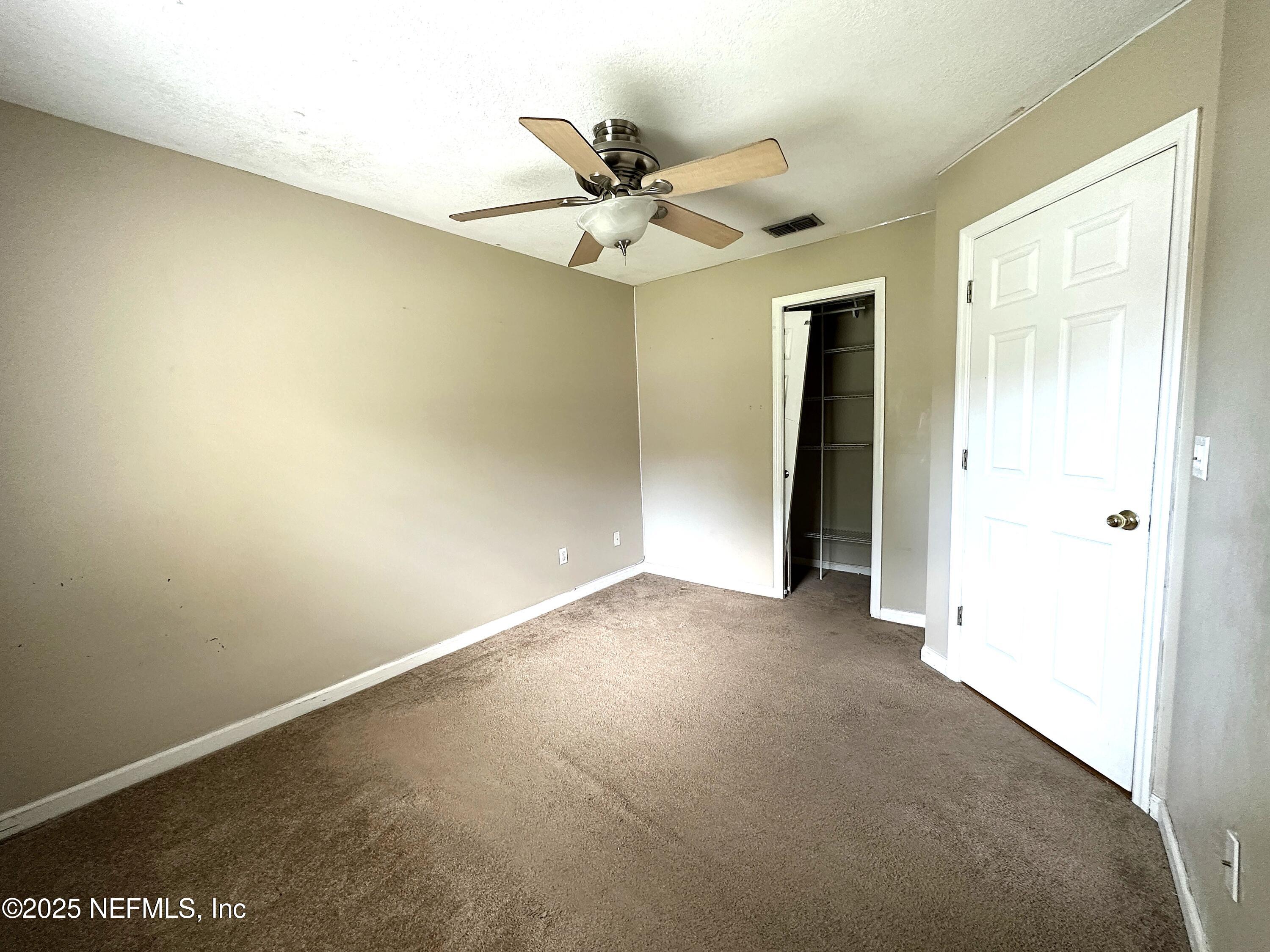 83041 St Mark Drive Yulee, FL 32097 - Photo 15 of 28 an empty room with a ceiling fan and window