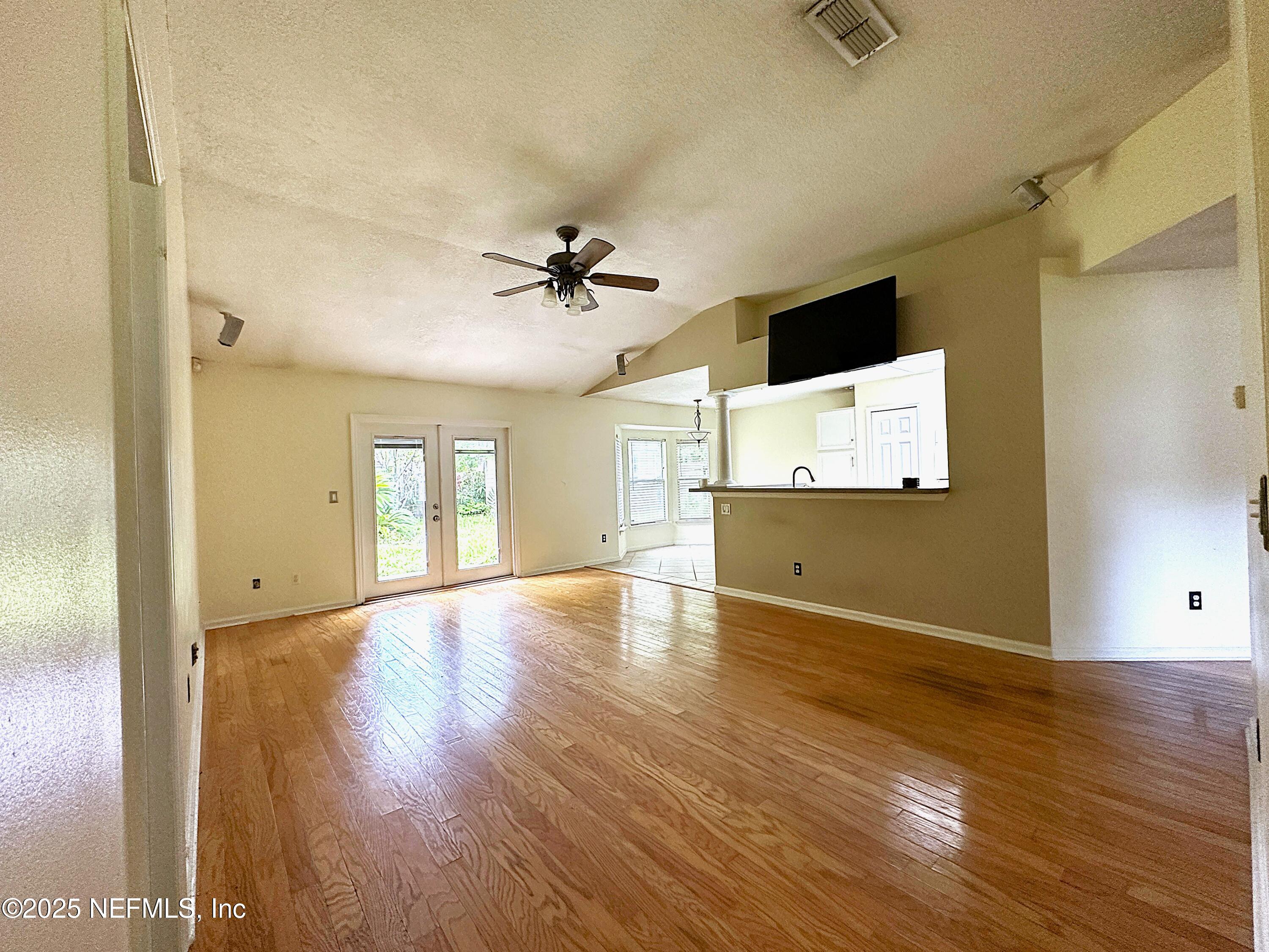 83041 St Mark Drive Yulee, FL 32097 - Photo 3 of 28 a view of an empty room with wooden floor and a window