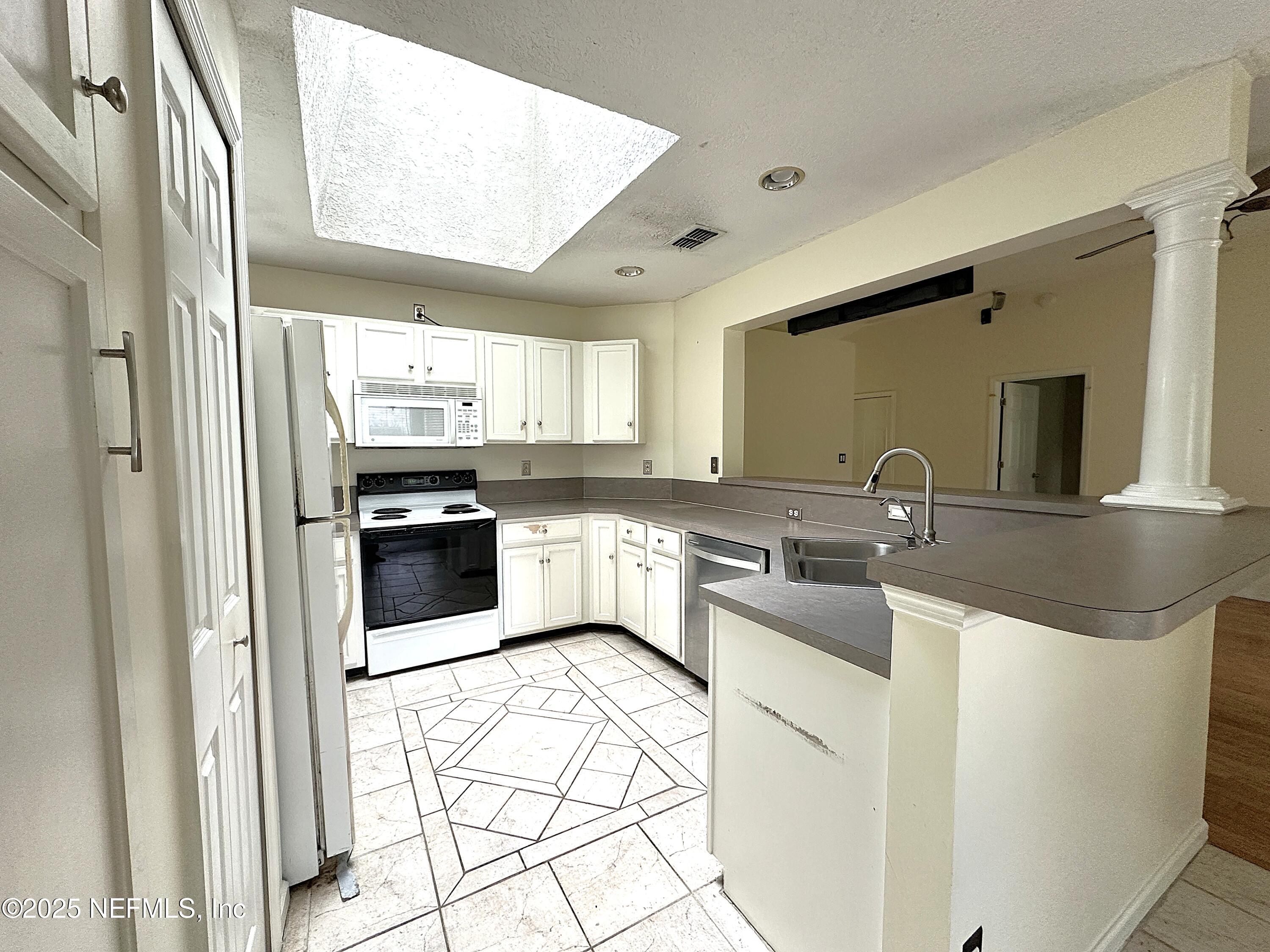 83041 St Mark Drive Yulee, FL 32097 - Photo 7 of 28 a kitchen with white cabinets and white appliances