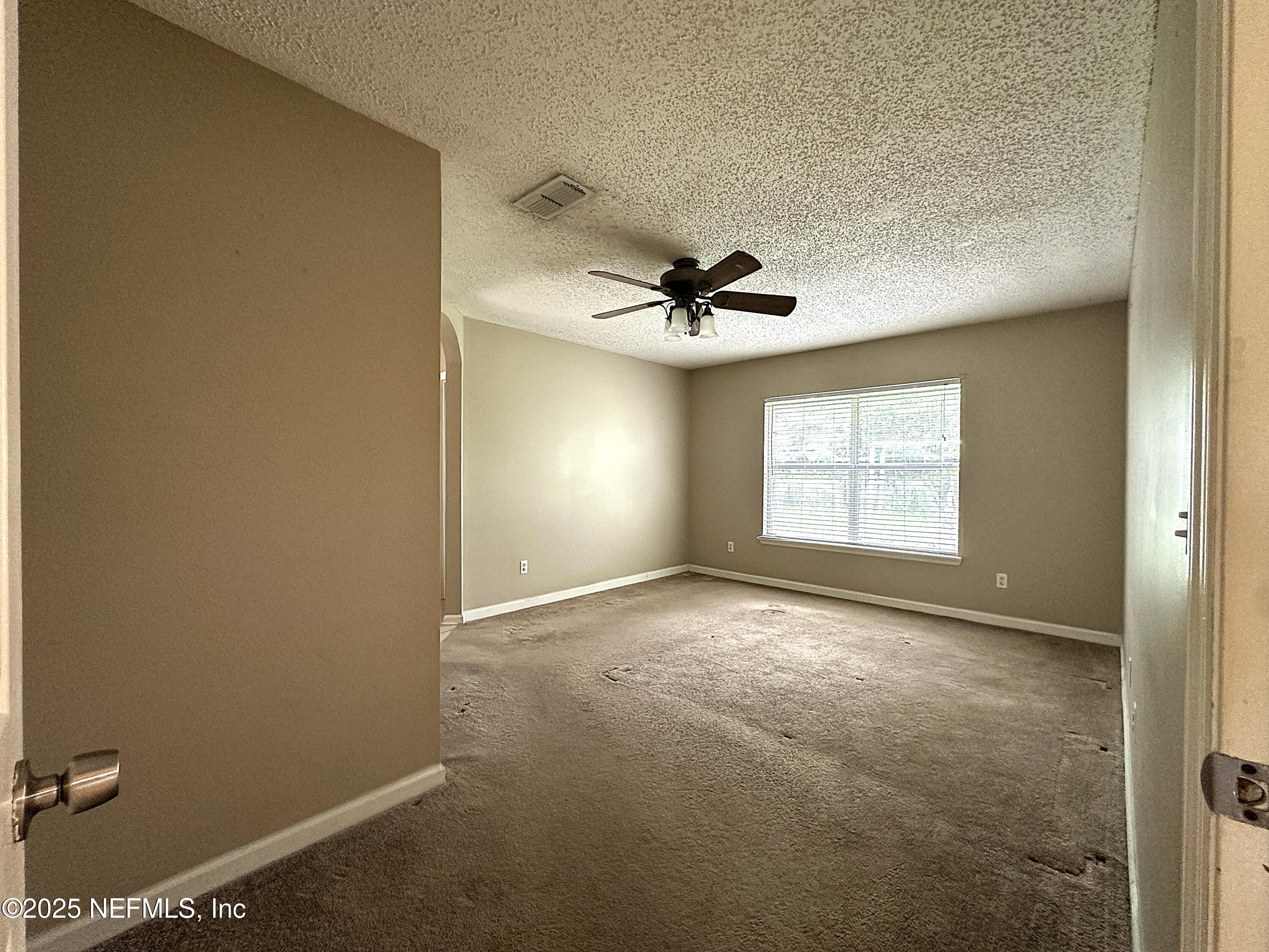 83041 St Mark Drive Yulee, FL 32097 - Photo 9 of 28 an empty room with windows and ceiling fan view
