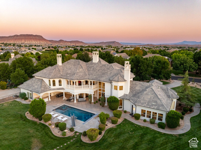 213 East Adam Lane Washington, UT 84780 - Photo 1 of 1 Back of house at dusk with a patio, stucco siding, a chimney, and a mountain view