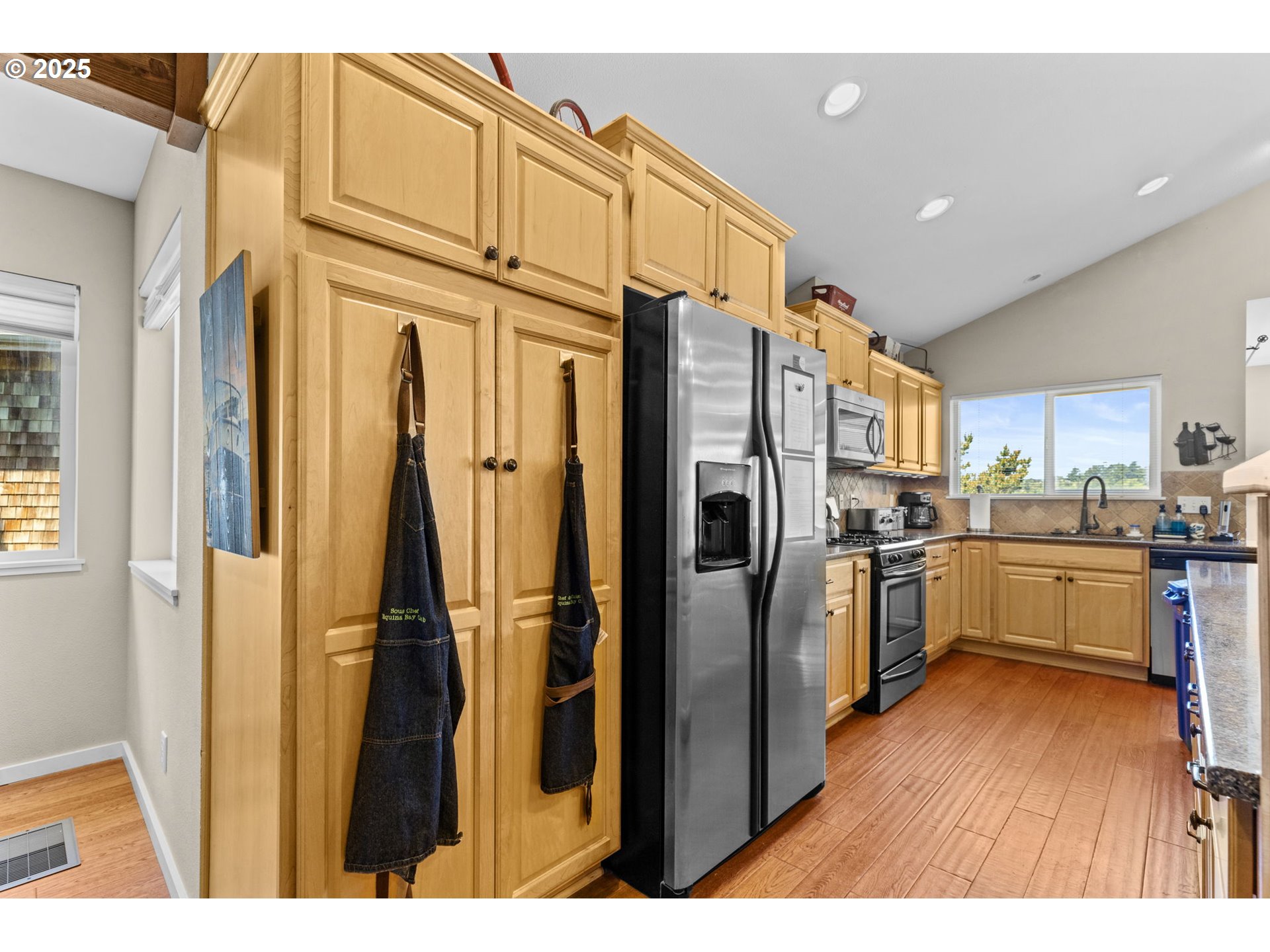 238 Southwest 27th Street Newport, OR 97366 - Photo 10 of 34 a open kitchen with stainless steel appliances granite countertop a refrigerator a oven a sink dishwasher and white cabinets with wooden floor