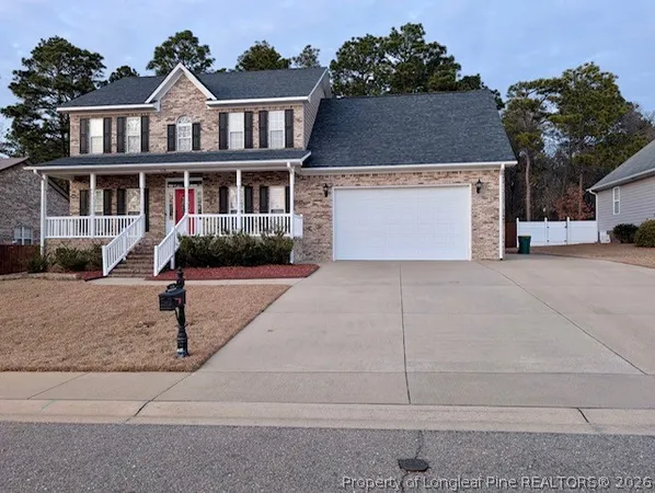 a front view of a house with yard and parking