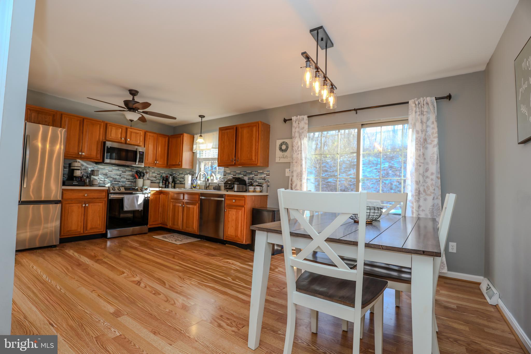 407 Crosswinds Drive Lititz, PA 17543 - Photo 3 of 18 a kitchen with stainless steel appliances kitchen island granite countertop a refrigerator a sink dishwasher a stove and white countertops with wooden floor