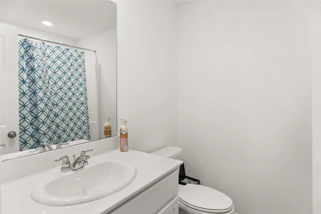 a bathroom with a sink toilet and a mirror