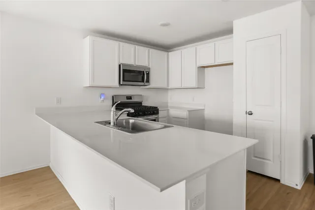 a kitchen with a sink a microwave and cabinets