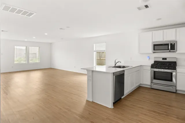 a kitchen with granite countertop a stove and a wooden floors