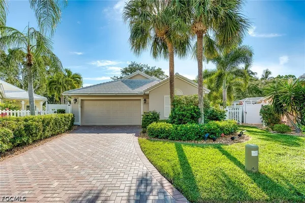 a front view of a house with a yard and potted plants