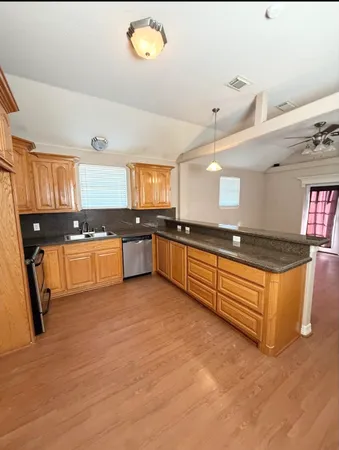 a large kitchen with stainless steel appliances granite countertop a stove granite counter tops and white cabinets