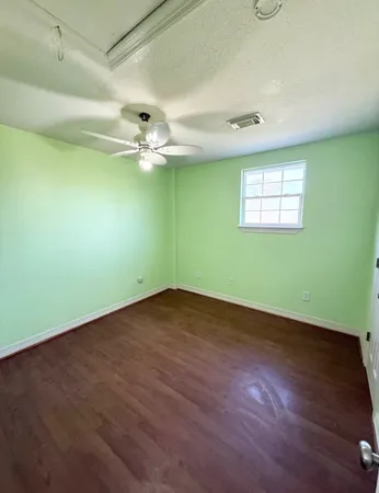 an empty room with a window and a ceiling fan