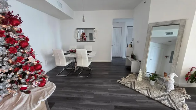 a bedroom with a bed wooden floor and a flat tv screen on a dresser
