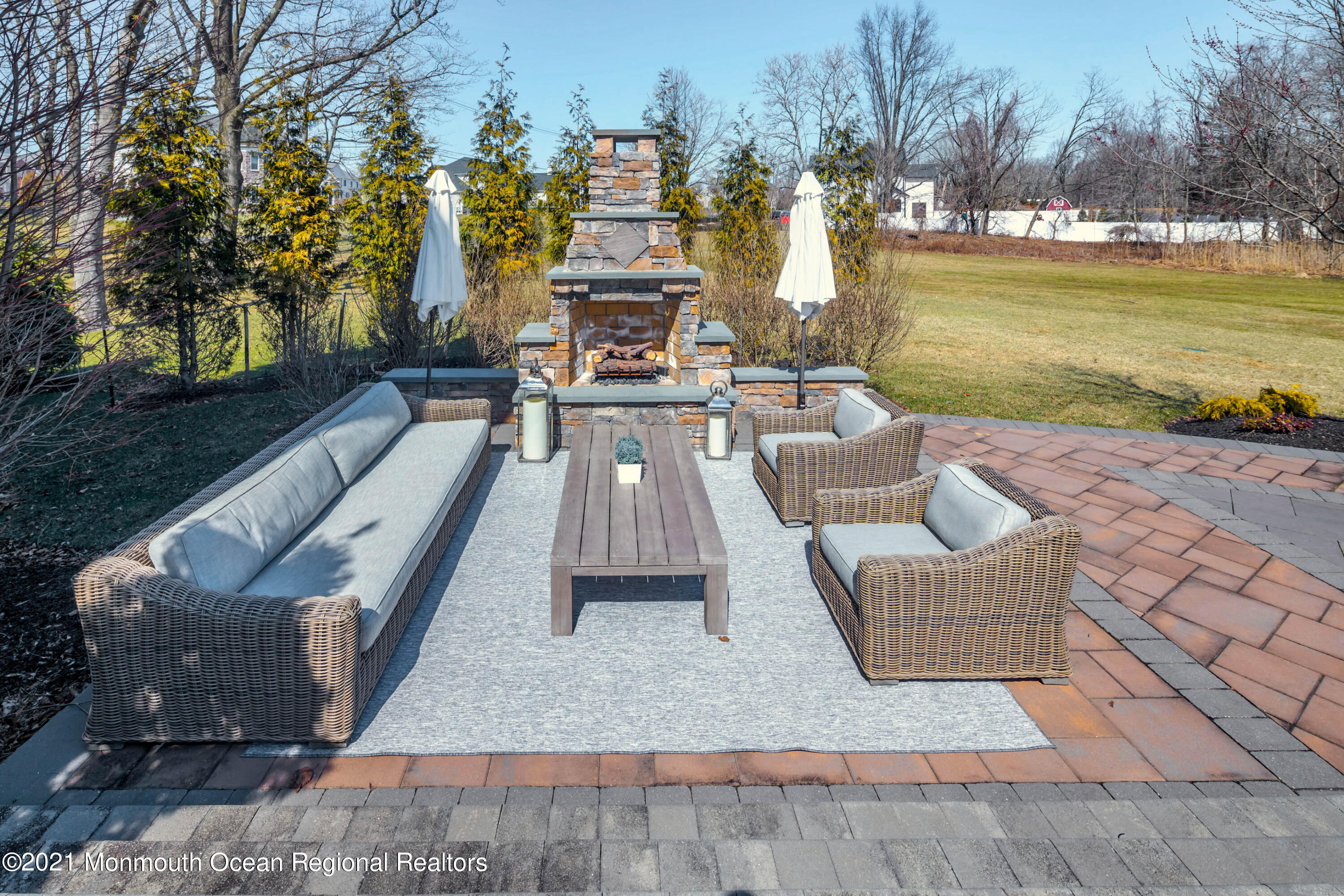 8 Strathmore Road Lincroft, NJ 07738 - Photo 67 of 76 a view of a patio with couches chairs and a fire pit
