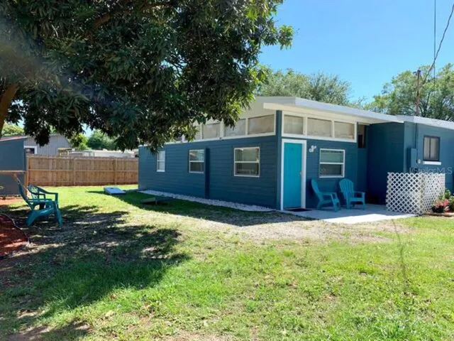 a front view of house with yard and trees in the background